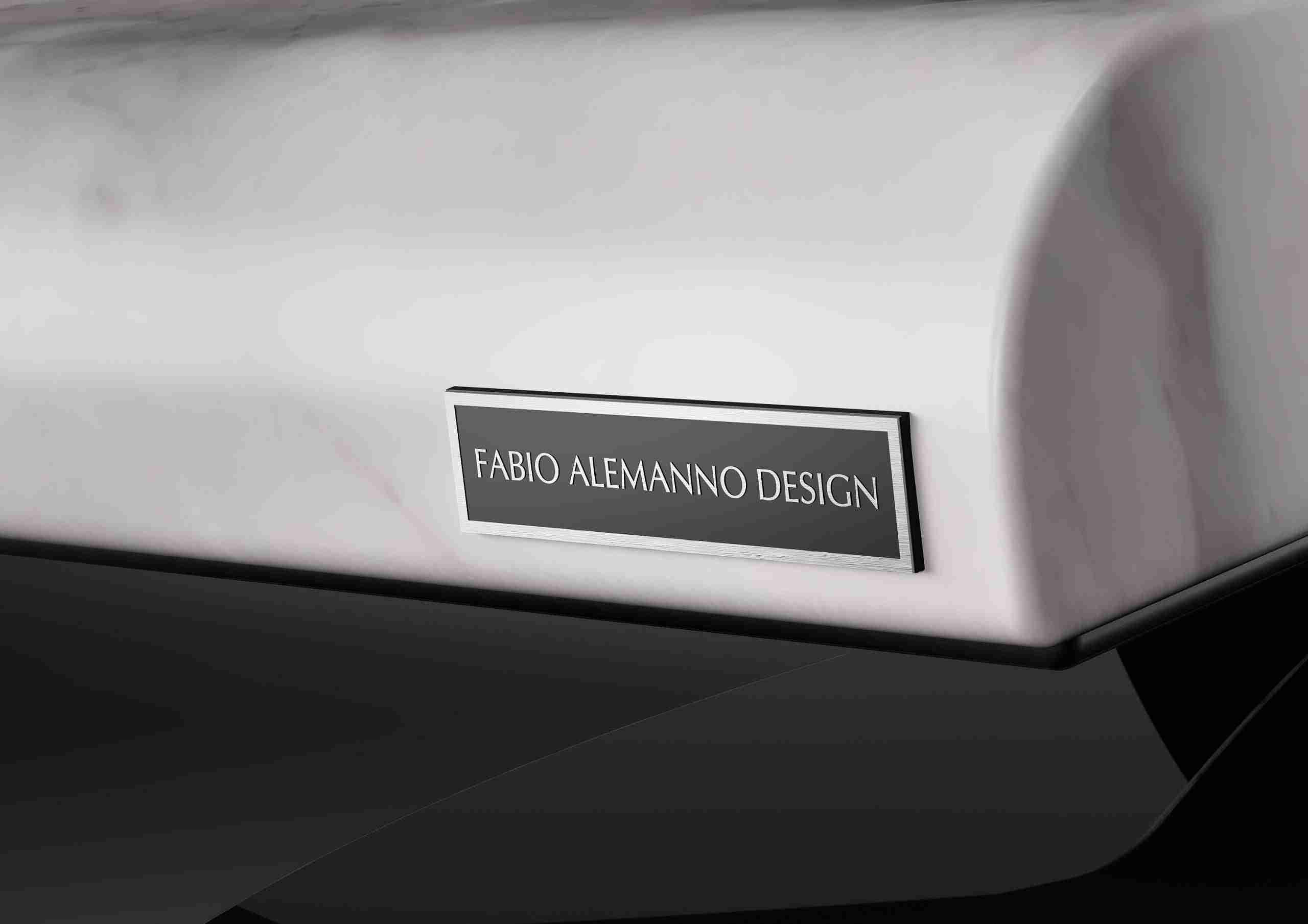 Detail Of The Cleopatra Moderno Heated Lounger Plaque With Fabio Alemanno Design Logo. A Refined Close-Up Showcasing The Craftsmanship And Luxury Marble Materials Of This Spa Lounger.