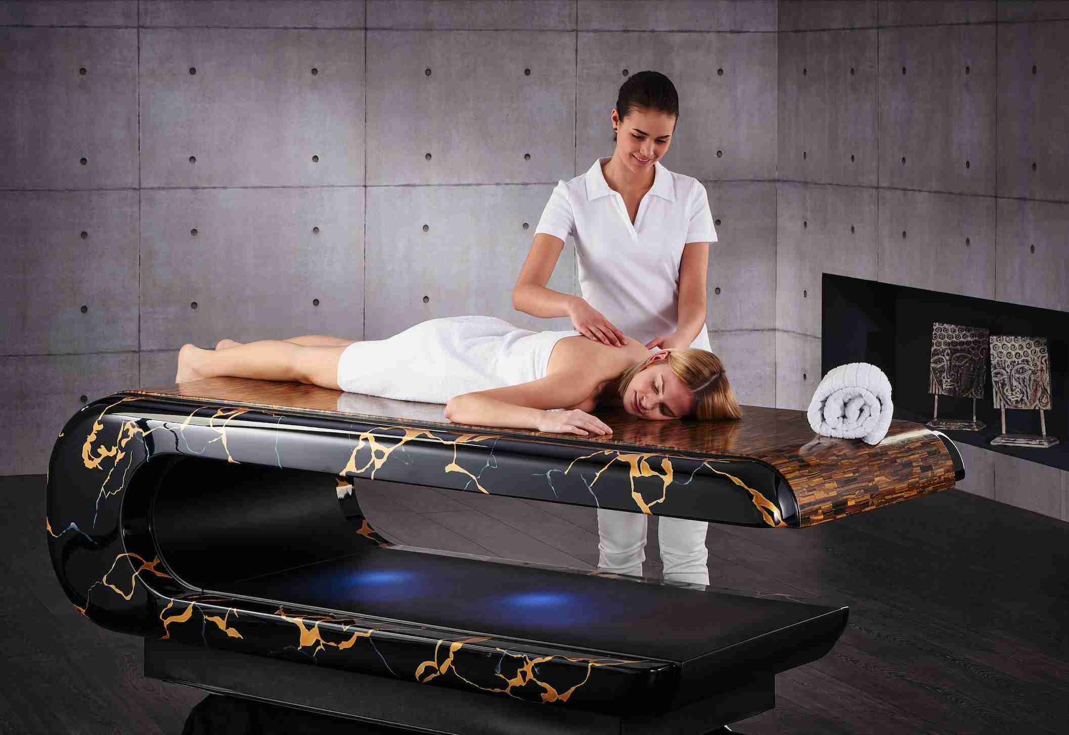 Luxury Heated Tiger Eye Stone Massage Table During Treatment With Therapist.