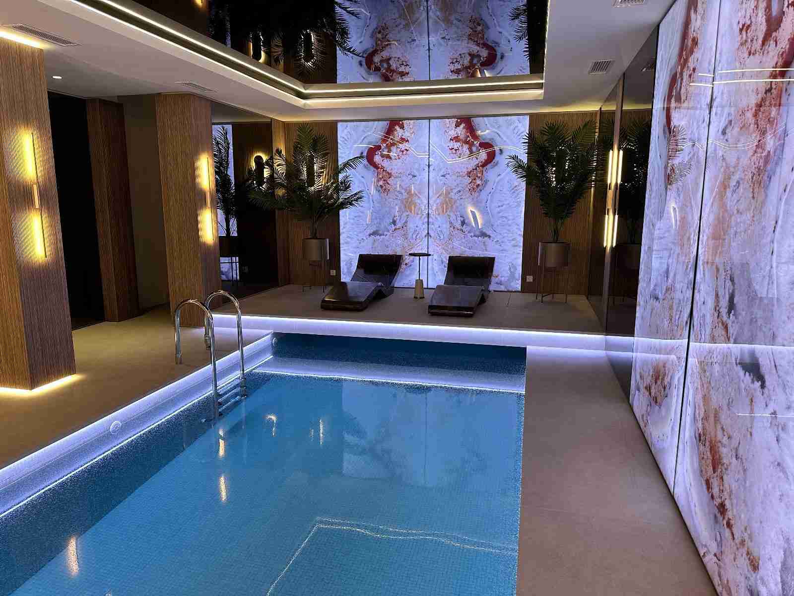 Cleopatra Basico Heated Marble Loungers — Aspen Club Front Pool Angle Showing Elegant Symmetry And Warmth.