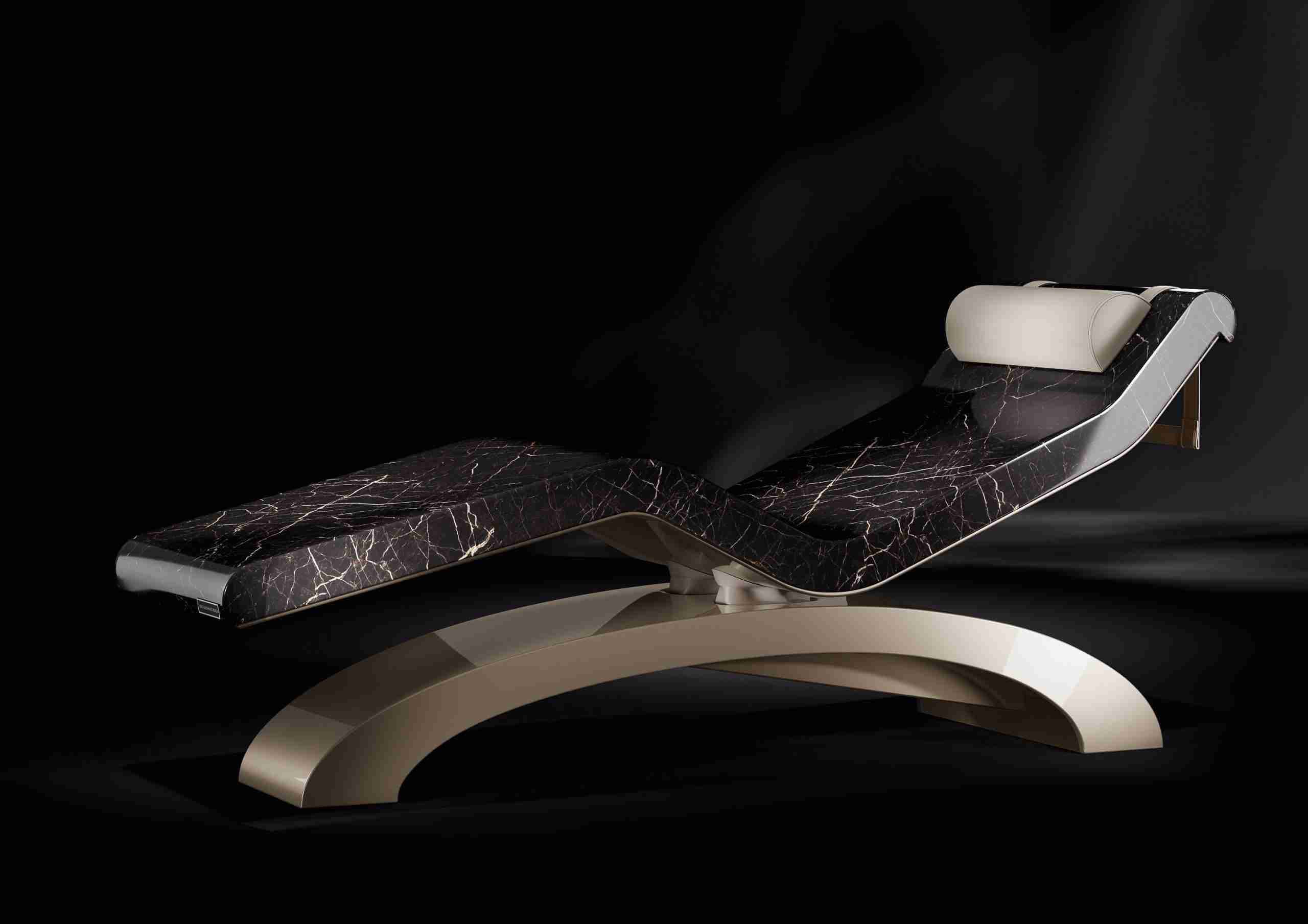 Front View Of Cleopatra Classico Heated Marble Lounger Showing Monolithic Surfaces And Sculpted Base.